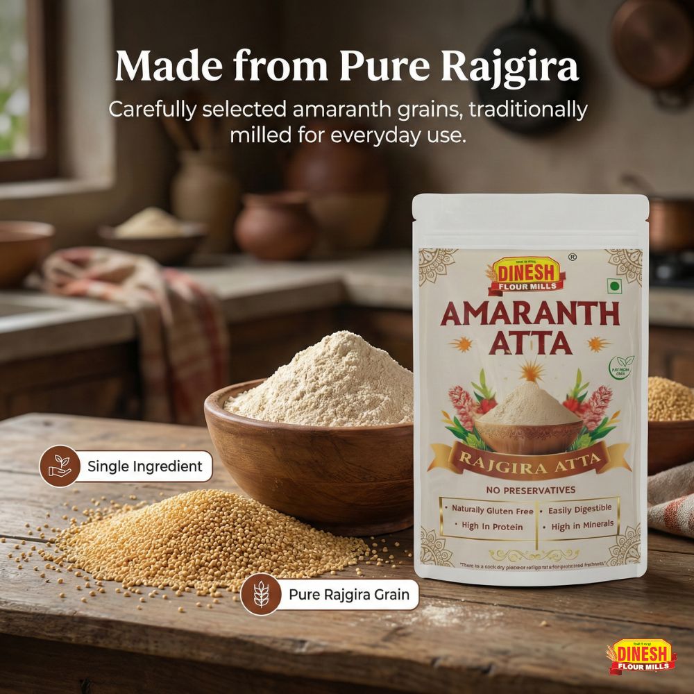 Dinesh Flour Mills Amaranth Atta package with amaranth grains and flour on a wooden surface.