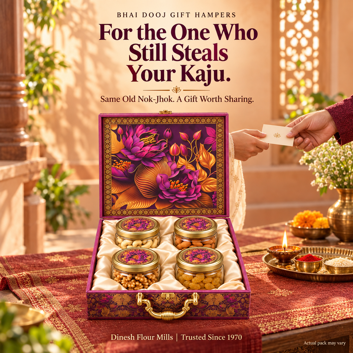 Dinesh Flour Mills Blossom four-jar dry fruit gift hamper on a terracotta table with a Bhai Dooj thali and a warm peach courtyard background.