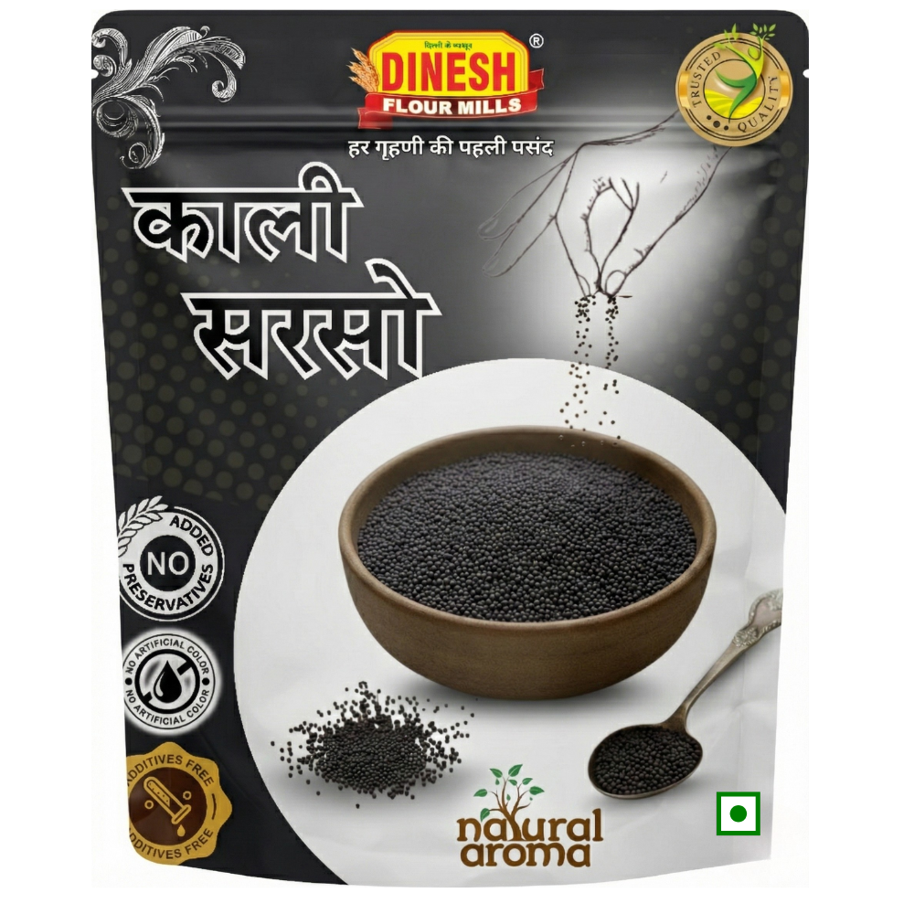 A stand-up pouch of Dinesh Flour Mills Kalli Sarso (black sesame) against a white background. The packaging is primarily black and white, featuring a central graphic of a brown bowl filled with black sesame seeds, a spoon with seeds, and Hindi text.
